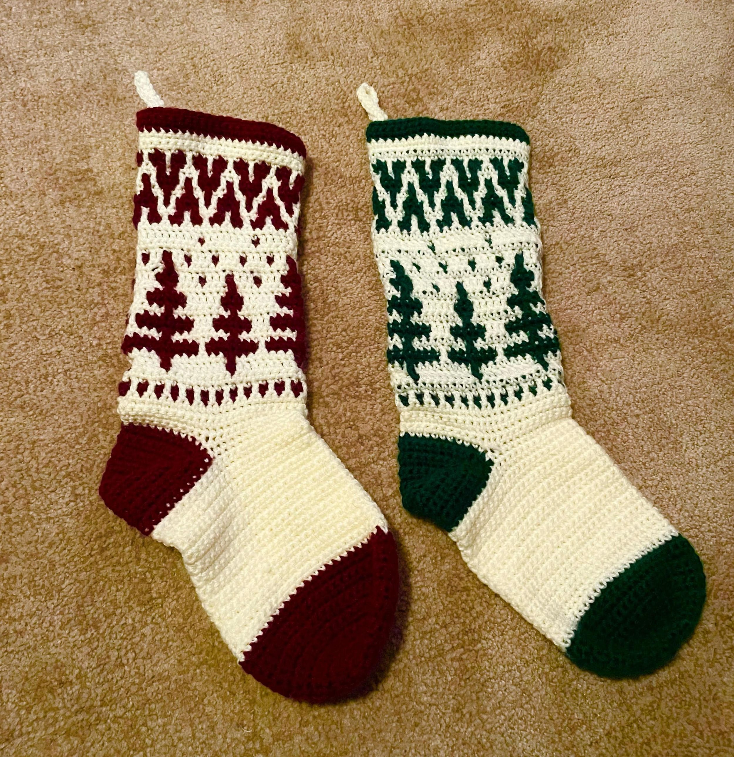 two crochet christmas stockings on a pale tan fluffy bloanket