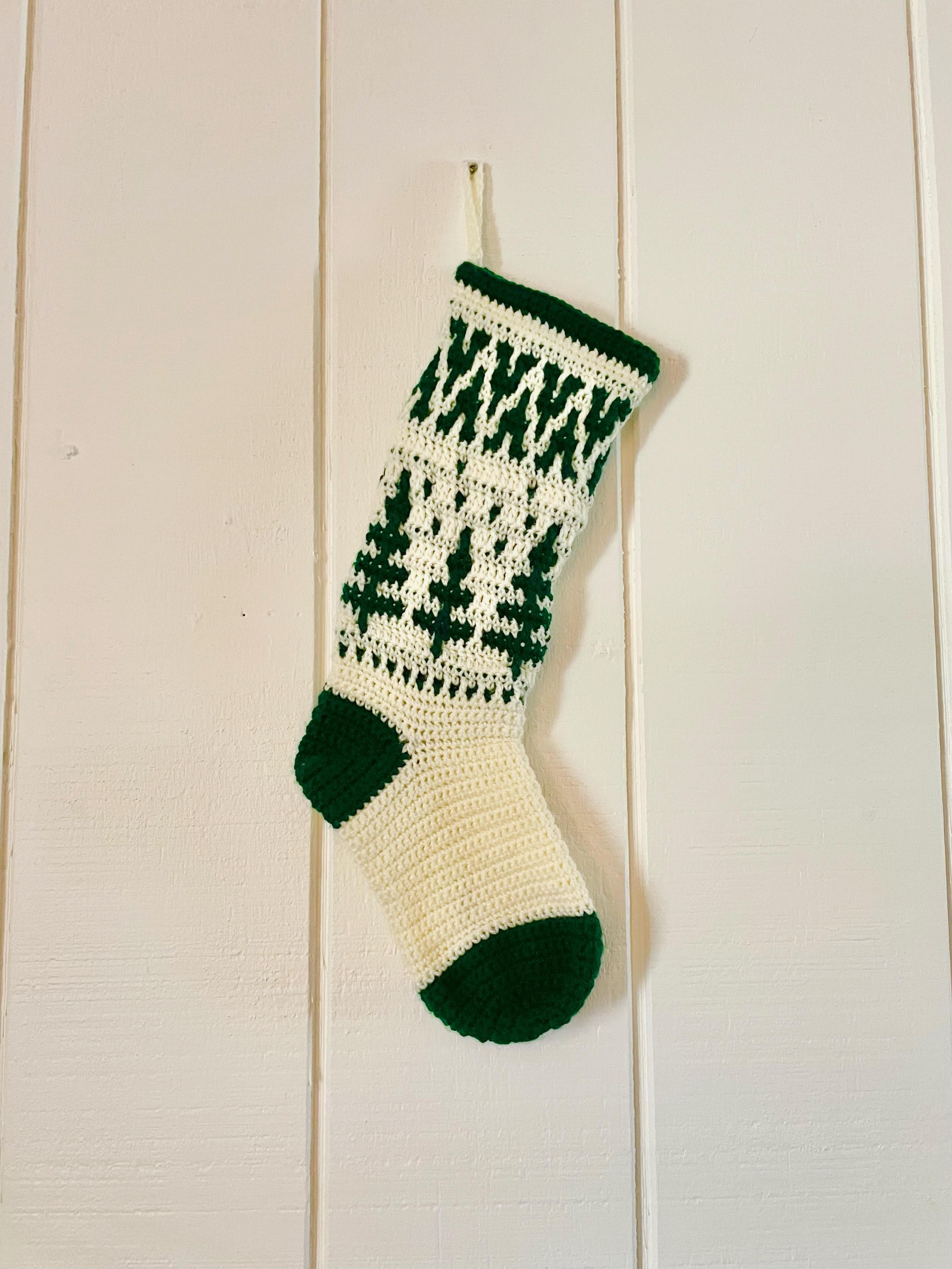 green and white stocking hanging on a white wooden door