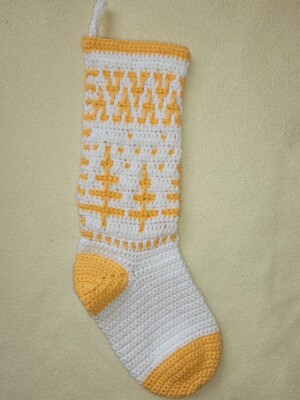 yellow and white crochet christmas stocking on a lemon coloured background